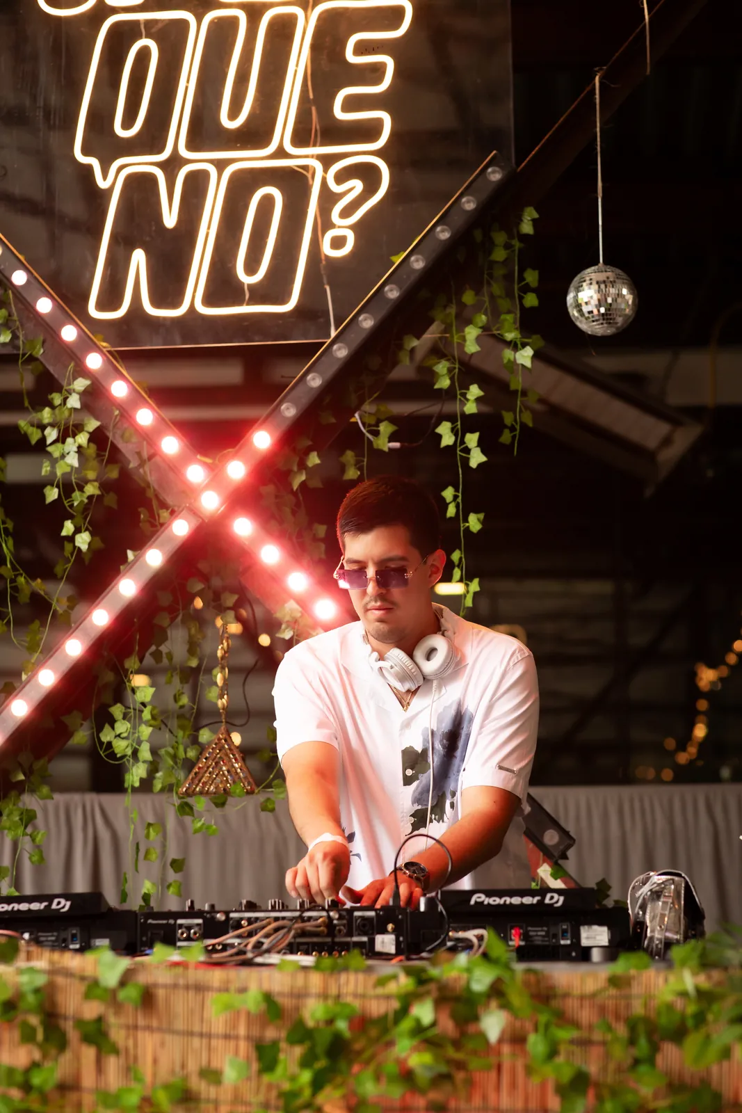 Azul DJing under the Por Que No neon sign